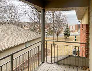 a balcony with a metal railing and a brown awning