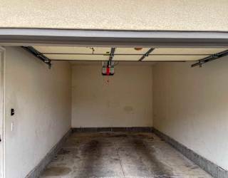 a garage with a white door and a concrete floor