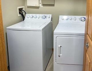 a white front loading washing machine and dryer in a double door closet
