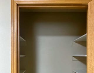 a wooden pantry with shelves and a door