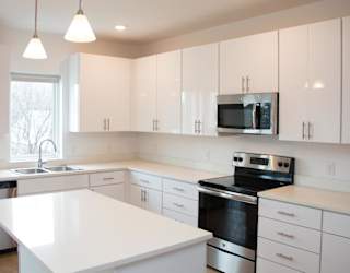A spacious kitchen with white cabinets and stainless steel appliances.