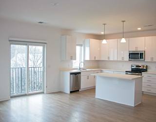 A kitchen with white cabinets and a large island.