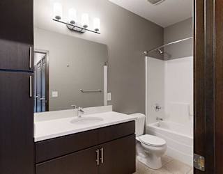 a bathroom with a large granite countertop vanity sink sink and a combo shower and tub