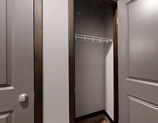 a hallway coat closet with built-in shelving and hanging space