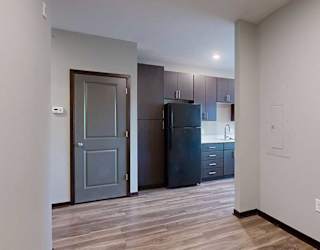a view of the kitchen with dark cabinets from the sleeping area