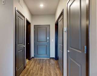 an entry hallway with access to the bathroom, laundry, and closets