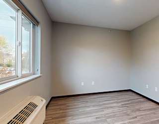a living area with a window and hardwood floors