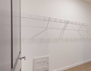 a wide walk-in closet with built-in shelving and hanging space