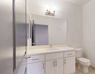 an attached bathroom with a granite vanity sink and a walk-in shower
