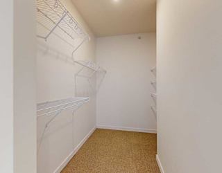 a large walk in closet with built-in shelving and hanging space