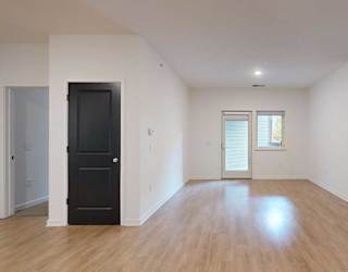 a living room with access to the patio and parallel bedrooms on opposite sides