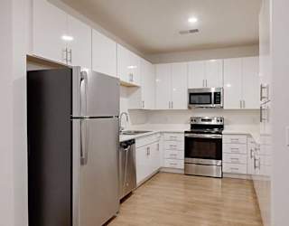 a modern kitchen with light cabinests, granite countertops, and stainless steel appliances