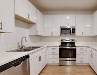 a modern kitchen with white cabinets and stainless steel appliances
