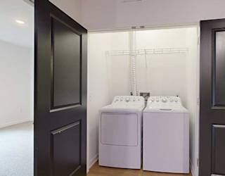 a laundry closet with side-by-side full sized washer and dryer