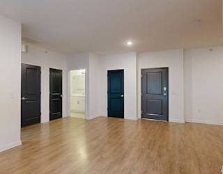 a view from the living room of the front door, and the hallway bathroom