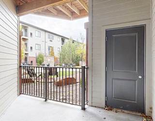 an elevated patio overlooking the courtyard with a door to the outdoor storage space