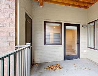 a patio with a glass door and a two windows