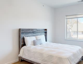 Furnished apartment bedroom with large single window