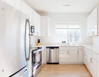 Furnished apartment kitchen with white finish style and stainless steel appliances
