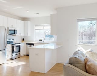 Furnished apartment kitchen with white finish style and stainless steel appliances