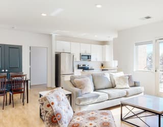 Furnished apartment living room with sofa, lounging chair, and coffee table