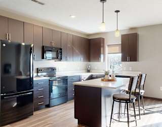 Furnished apartment kitchen with dark finish style and all black kitchen appliances