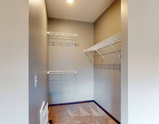 Walk in closet with plenty of shelving and hanging space in a furnished apartment at the conrad