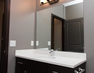A bathroom with a white sink and a mirror above it.