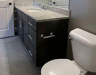 Large bathroom with dark vanity and large mirror