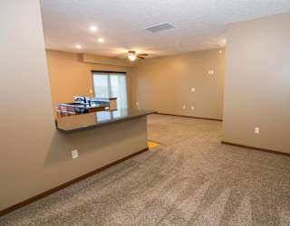 A spacious dining space or office with a carpeted floor and a window.