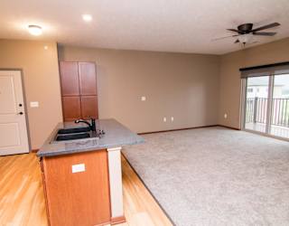 A kitchen with an island, open to a large living room