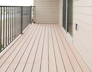 A wooden deck with a metal railing and a sliding glass door.