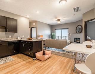 an open kitchen and living room with a fireplace and a table