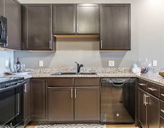 Style A design with dark cabinetry and light granite countertops
