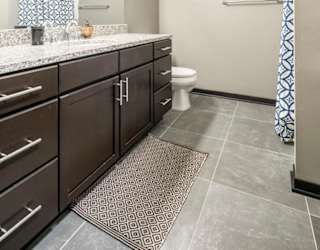 Bathroom with granite countertops and tile flooring at The Flats at 84 in southeast Lincoln NE 68516