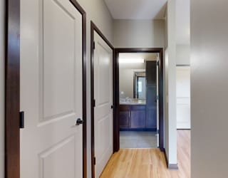 a hallways with doors to the bathroom, laundry room, and closet
