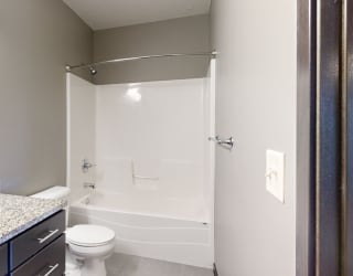 a bathroom with a shower tub combo and toilet and sink