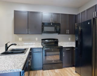 a kitchen with dark cabinets and granite countertops