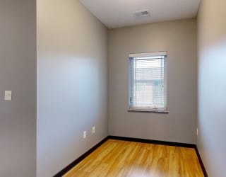 a unique nook with hardwood floors and a small window