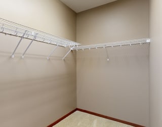 a large walk in closet with wire shelving