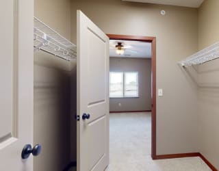 a walk through closet with two hanging shelves