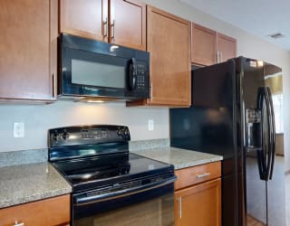 a kitchen with black GE appliances and granite counter tops