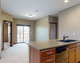 a kitchen counter top with a stone sink in front of a dining room