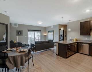 A modern kitchen with dark wood cabinets and a dining table set for two