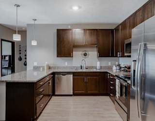 A modern kitchen with dark wood cabinets and stainless steel appliances