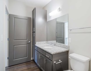 a bathroom with a granite countertop sink and storage