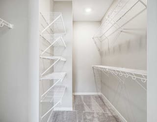 a walk in closet with built-in wire shelves and hanging space