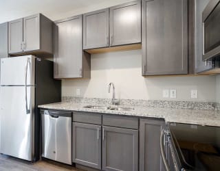 a kitchen with stainless steel appliances and grey cabinets