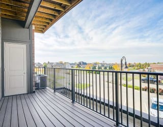 a balcony with a door to an outdoor stage closet and a view of the city