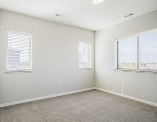 a bedroom with carpeting and several windows